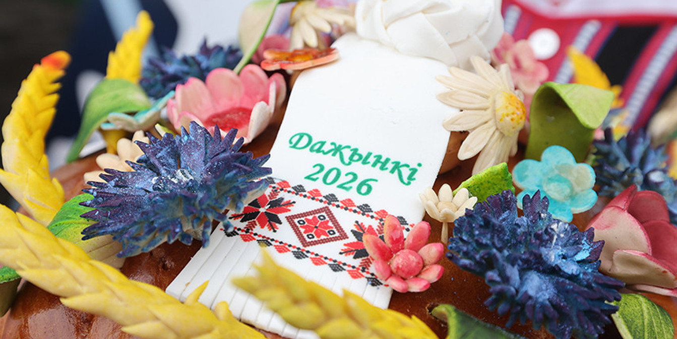 Праздничный каравай «Дажынкі 2026», украшенный колосьями пшеницы, яркими цветами из теста и декоративной лентой с белорусским орнаментом.