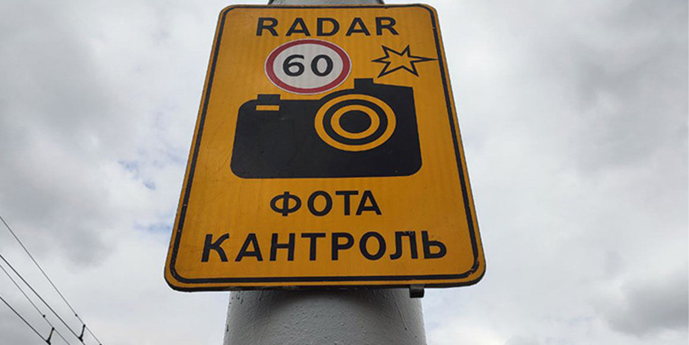 Дорожный знак на белорусском языке с надписью ФОТА КАНТРОЛЬ, радаром 60 и значком камеры.