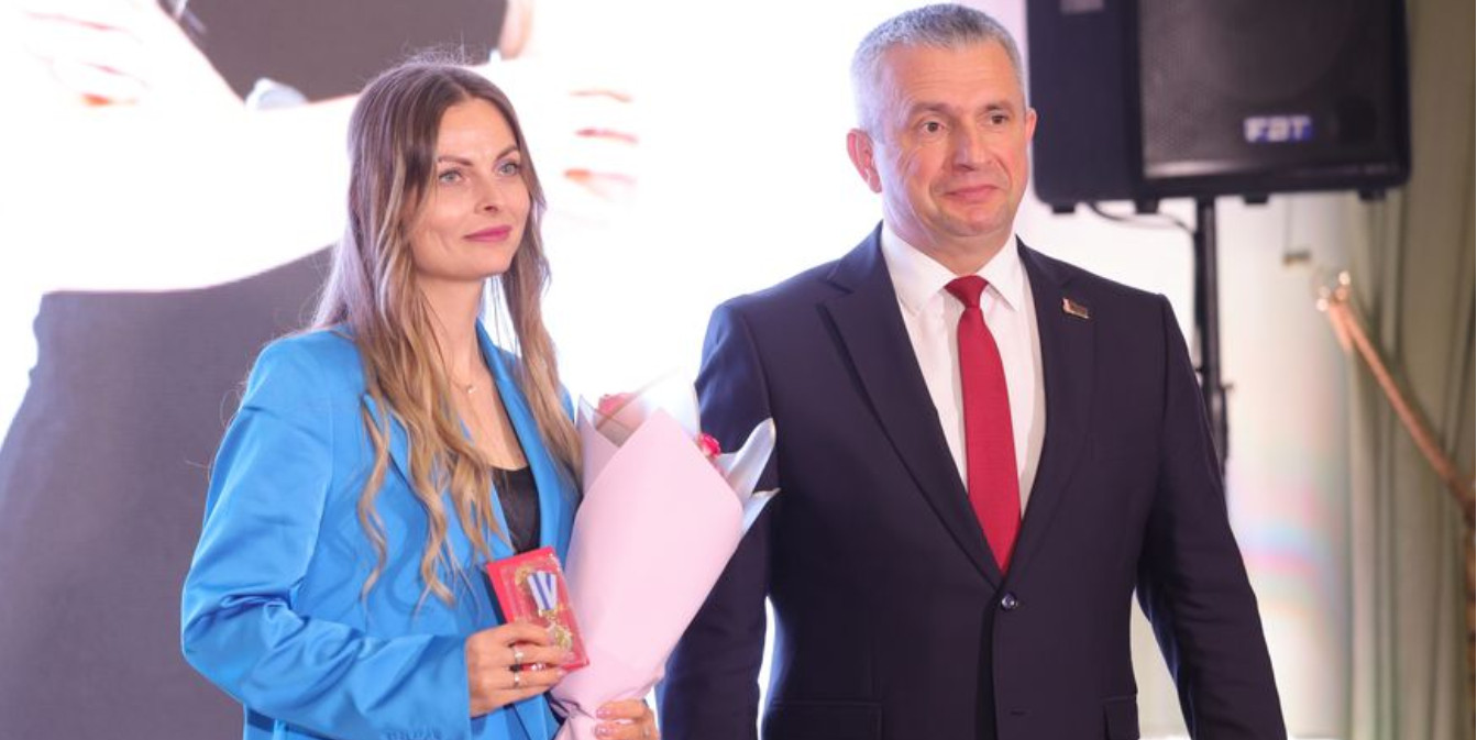 Председатель Гомельского облисполкома Иван Крупко стоит на сцене рядом с многодетной матерью, награжденной орденом Матери