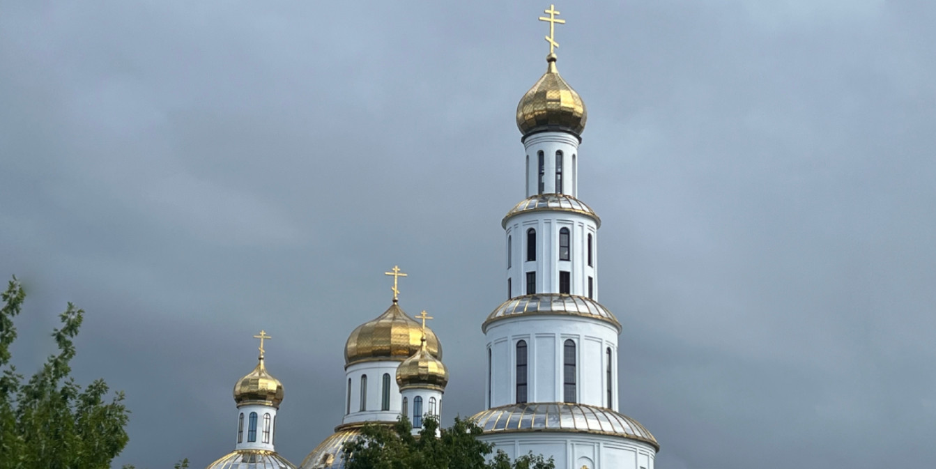 Позолоченные православные кресты и купола храма, устремленные в небо