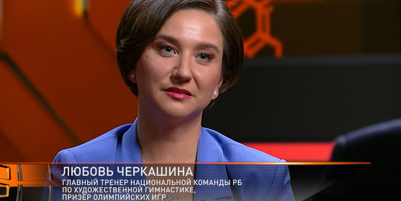 Любовь Черкашина, главный тренер сборной РБ по художественной гимнастике и призер Олимпиады, в синем пиджаке крупным планом во время телевизионного интервью.
