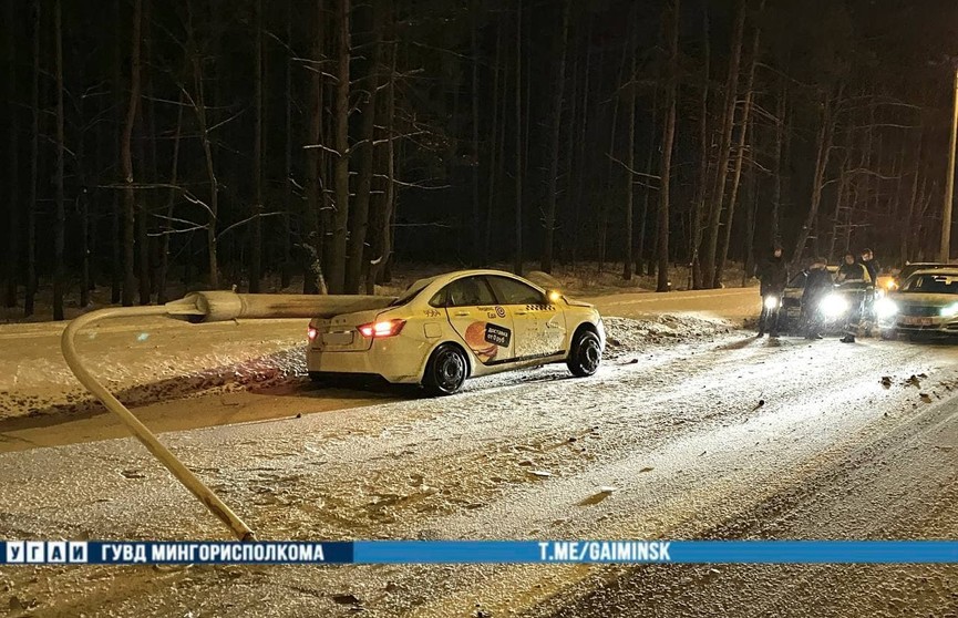 Такси потеряло управление и врезалось в осветительную мачту в Минске. От удара она упала на машину