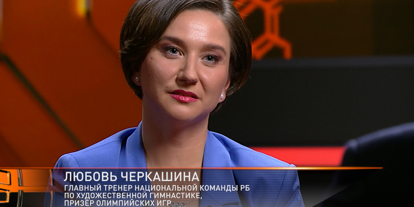 Любовь Черкашина, главный тренер сборной РБ по художественной гимнастике и призер Олимпиады, в синем пиджаке крупным планом во время телевизионного интервью.