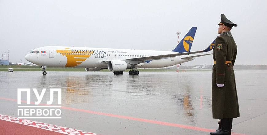 Самолет Mongolian Airlines приземлился в аэропорту Минска, на переднем плане в профиль стоит белорусский военный почетного караула.